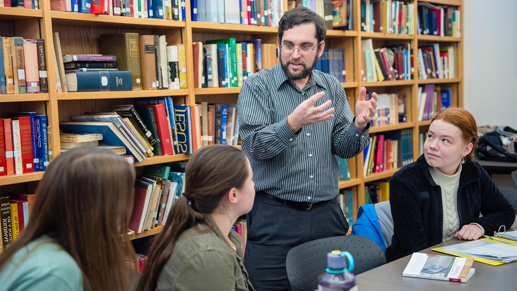 Joseph Stuart teaching a history class with his students listening attentively.